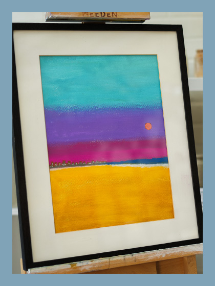 A hand painted art in a black frame on a easel