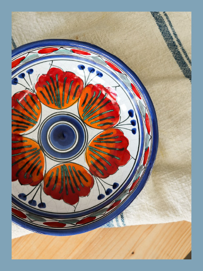 A picture of a beautiful plate hand painted with a poppy flower with a blue rim