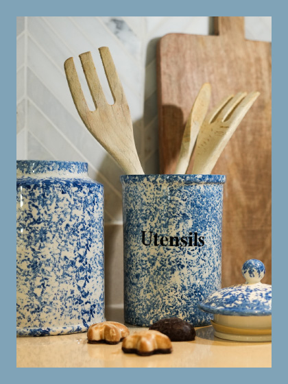 Wooden utensils in a vase with the label utensils and next to it a cookie jar