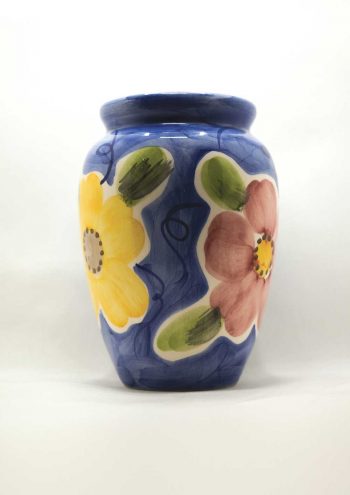 A blue flower vase with yellow, red and blue flowers