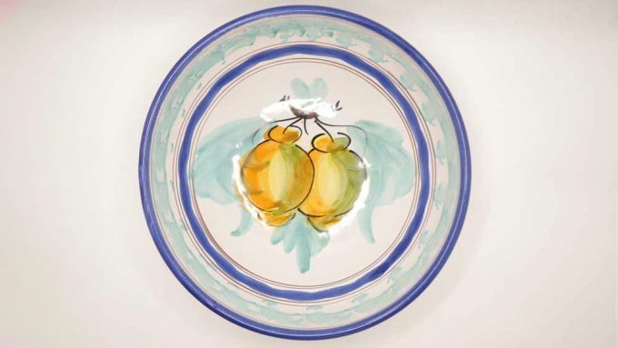 two hand painted lemons on a blue and white bowl made in italy