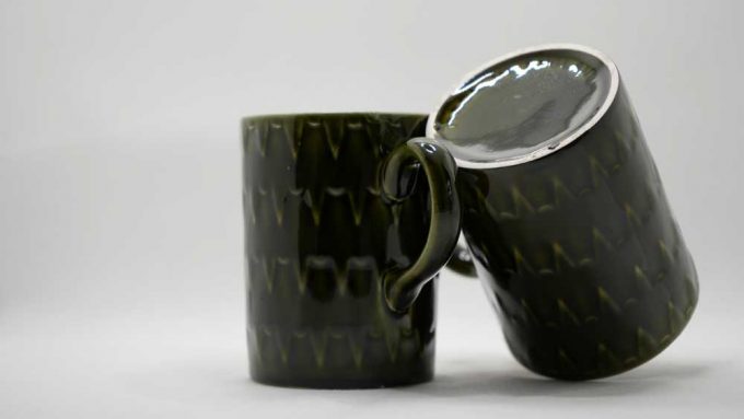 Two dark green mugs side by side